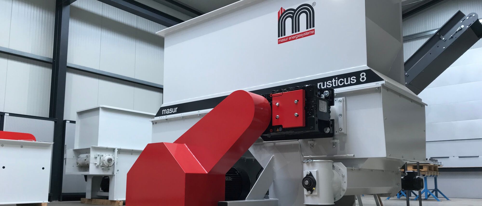 Maschinenanlage 'rusticus 8' von Masur Energiesysteme mit rotem Einlassrohr in Industriehalle